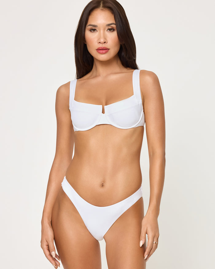 Front view of a model wearing the LSPACE white Mako Bikini Top, a structured underwire style with wide straps and center front keyhole detail, paired with a matching white Rocky Bikini Bottom.