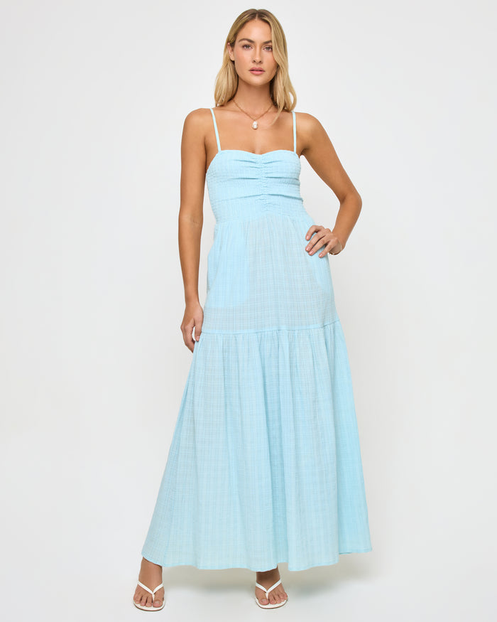Front view of a model wearing the LSPACE Mallorca Dress in ibiza blue, a maxi-length spaghetti strap dress with a ruched sweetheart bust and tiered skirt.