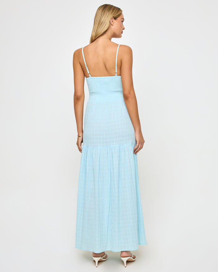 Back view of a model wearing the LSPACE Mallorca Dress in ibiza blue, showing the spaghetti straps, smocked back bodice, and tiered flowing maxi skirt.