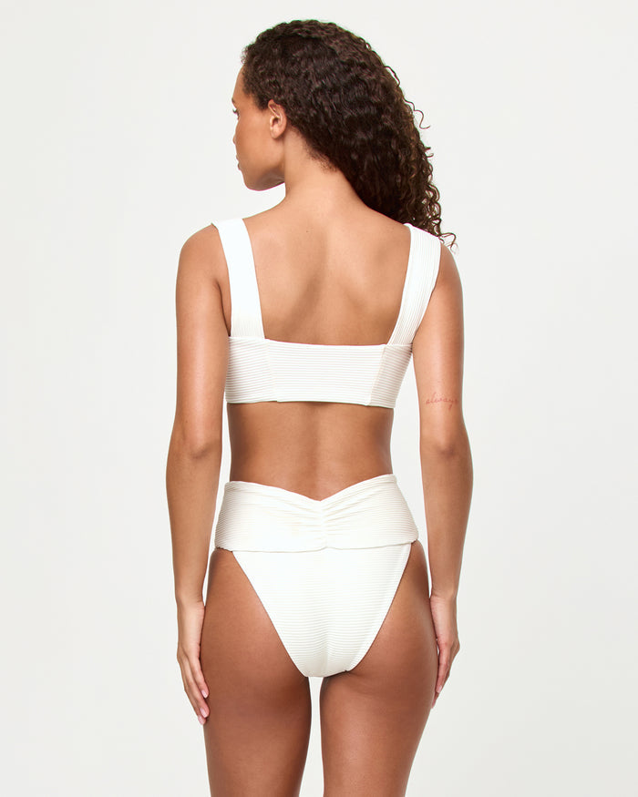 Back view of a model wearing the LSPACE ribbed cream Marlee Bikini Top, showing the wide straps and open back, paired with the matching Bardot Bikini Bottom.