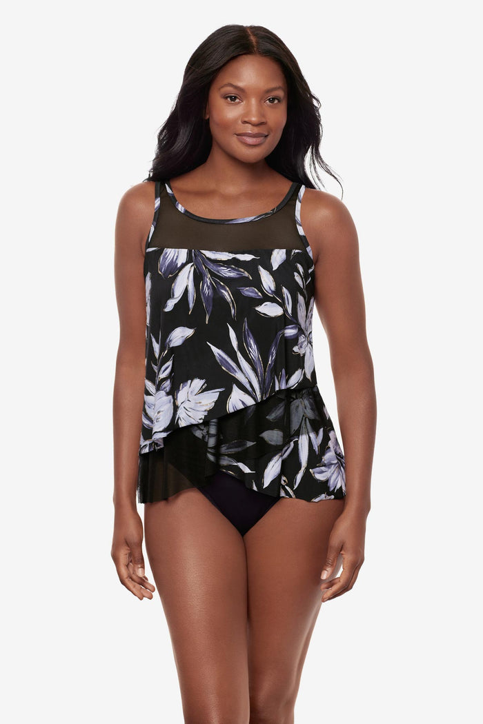 Woman wearing a black and white floral printed tankini top with mesh throughout