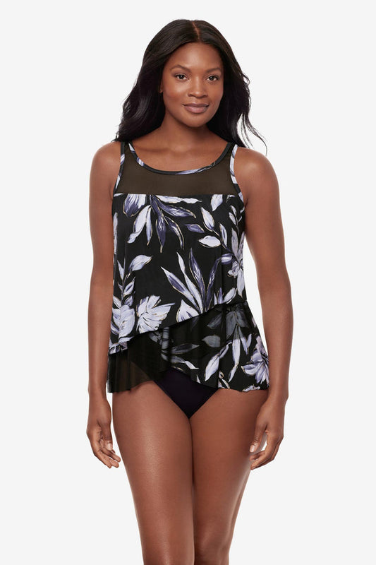 Woman wearing a black and white floral printed tankini top with mesh throughout