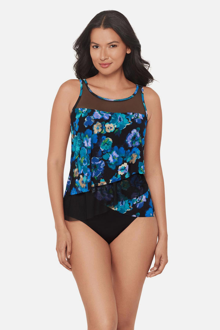 Woman wearing a black and blue floral printed tankini top with mesh details