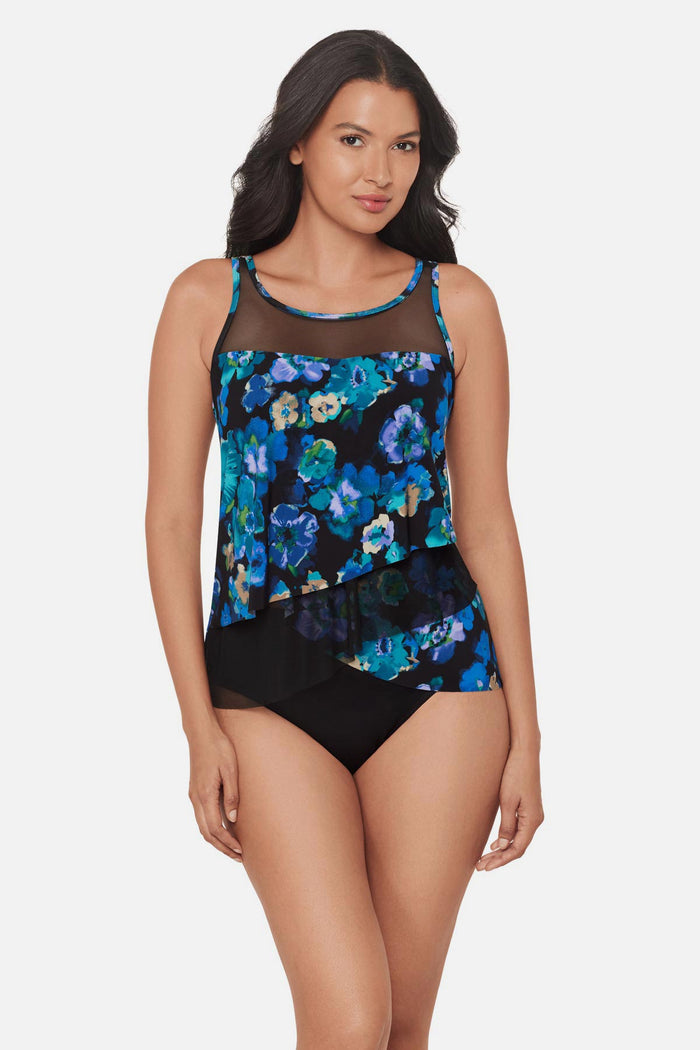 Woman wearing a black and blue floral printed tankini top with mesh details