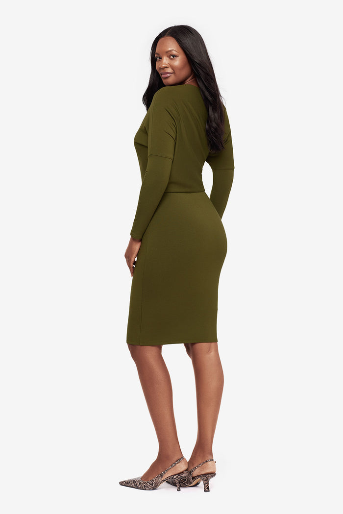 Woman turned left wearing a green long sleeve dress at knee length