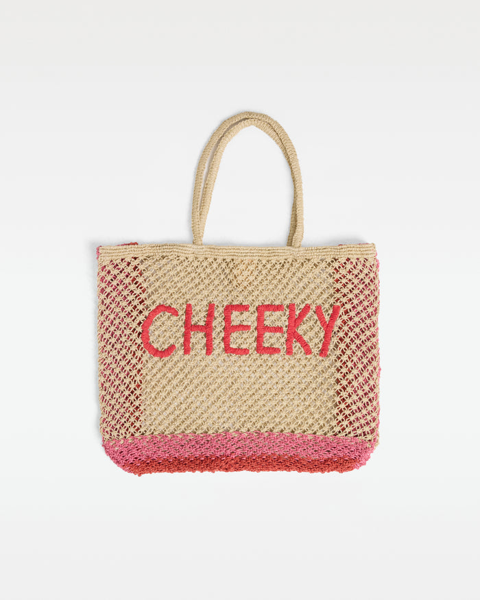Off-model front view of the Moonlight Bag in grapefruit-bubblegum, a large open-weave crochet tote bag with 'Cheeky' intarsia lettering in grapefruit red on a natural ground, with grapefruit and bubblegum pink border detail, on a white background.