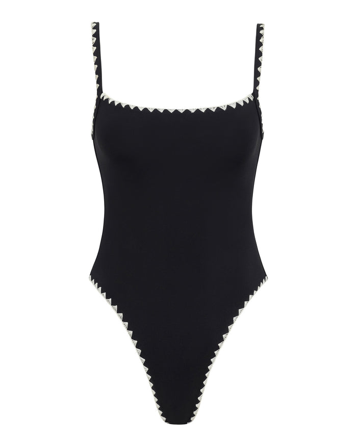 Off-model front view of the black-cream LSPACE Nadia One Piece Swimsuit on a white background, showing cream zig-zag trim around the square neckline, straps, and high-cut leg openings.