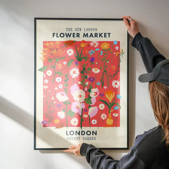 New London Flower Market Print being hung on a wall in a black frame