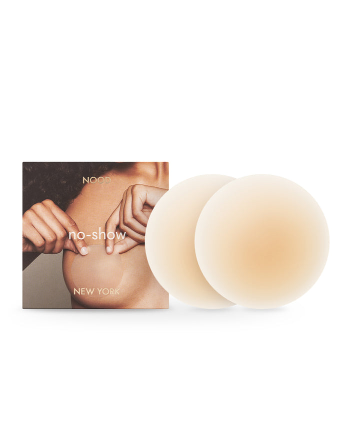 Off-model image of the NOOD No Show Adhesive Nipple Covers in buff with the NOOD branded packaging box.