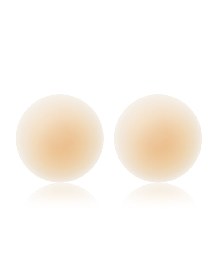 Off-model image of two round NOOD No Show Adhesive Nipple Covers in buff on a white background.