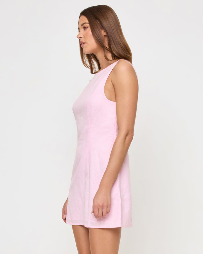 Side view of a model wearing the LSPACE Oceanside Mini in rosewater, a sleeveless mini dress with a fitted bodice and flared A-line skirt.