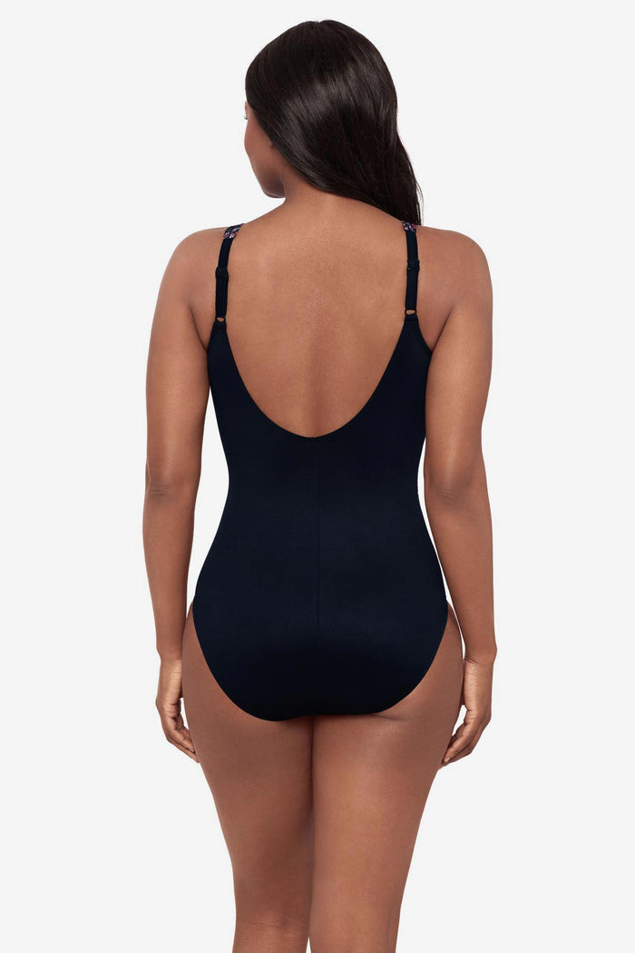 Woman turned away wearing a multicolor abstract print one-piece swimsuit