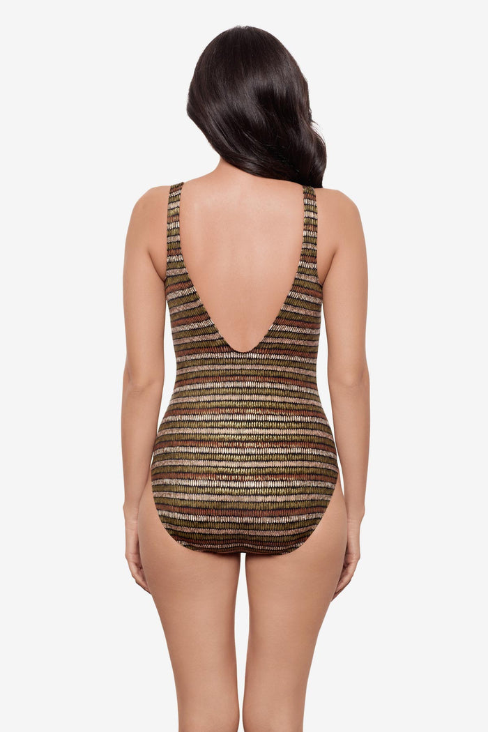 Woman turned away wearing a shimmery golden brown striped one-piece swimsuit