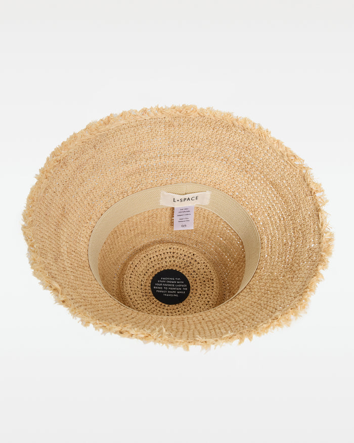 Top-down interior view of the Paco Bucket Hat in natural showing the LSPACE branding label and packing tip tag, with the frayed brim visible around the edge.