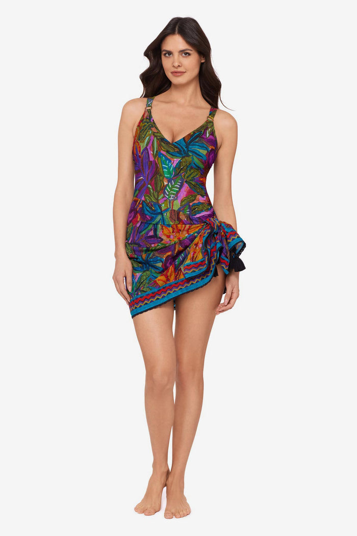 Woman wearing a jungle printed one-piece swimsuit with a matching swim cover up