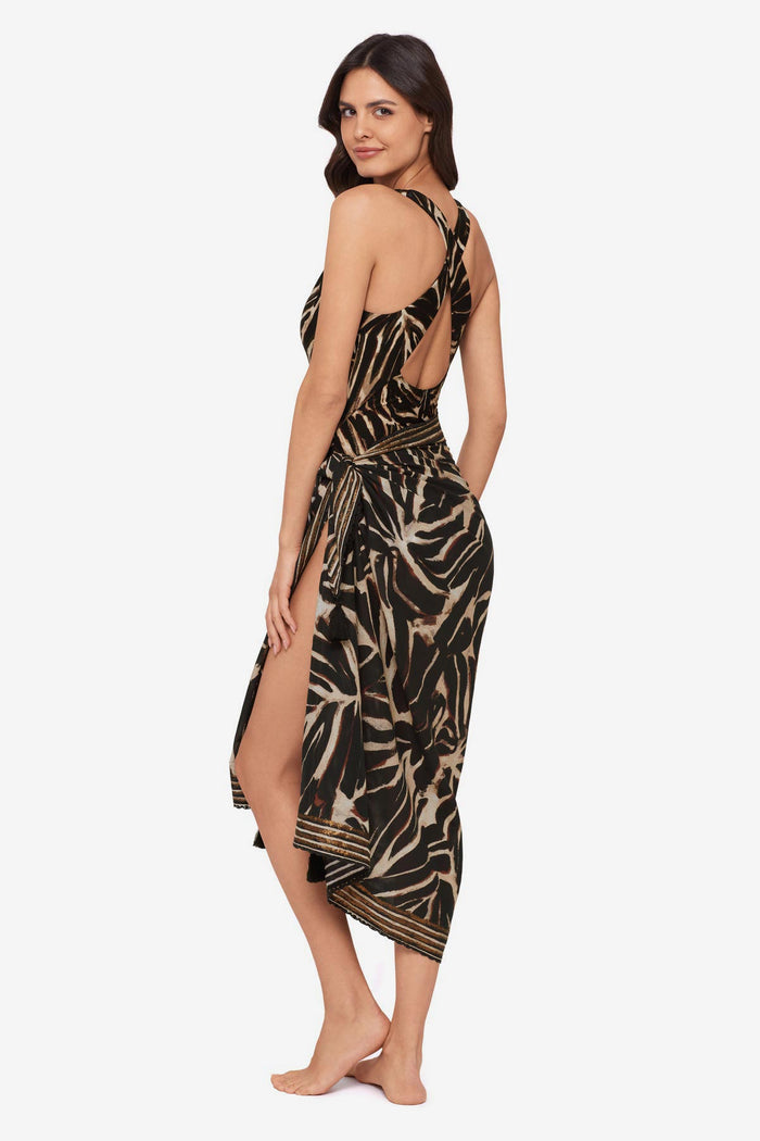 Woman turned left wearing a brown leaf printed one-piece swimsuit with a matching swim cover up