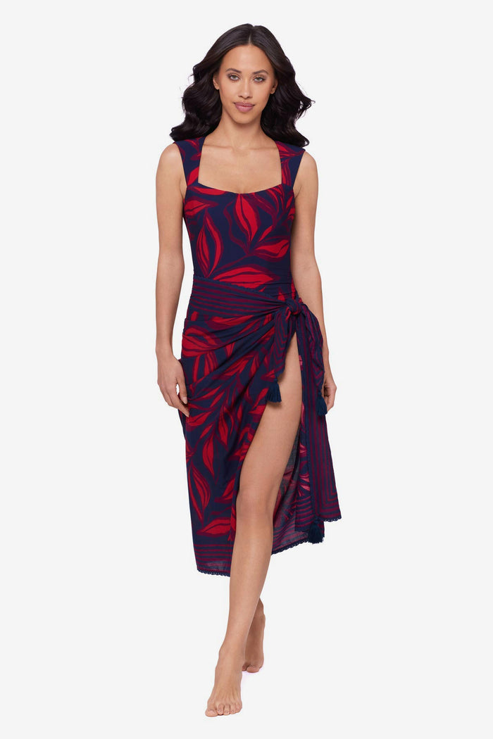Woman wearing a red leaf print one-piece swimsuit with a matching swim cover up