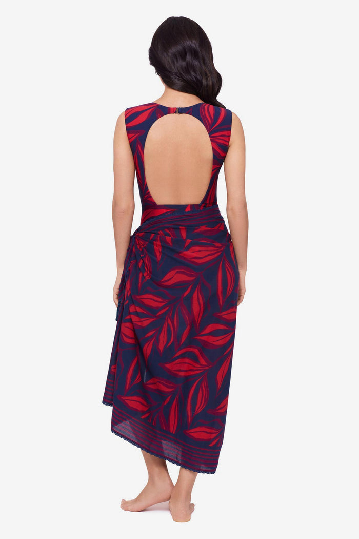 Woman turned away wearing a red leaf print one-piece swimsuit with a matching swim cover up