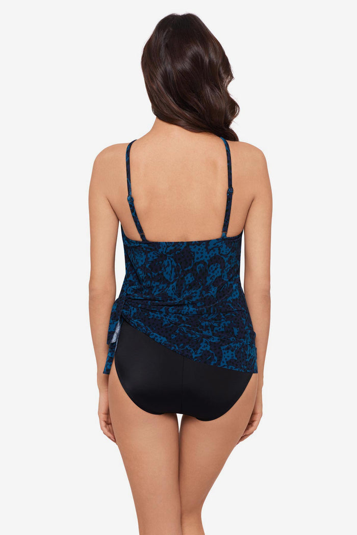 Woman faced away wearing a black and blue one-piece swimsuit with a tie side