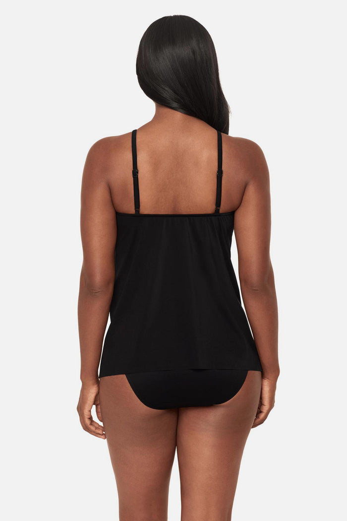 Woman turned away wearing a multicolored abstract floral printed peep hole tankini top