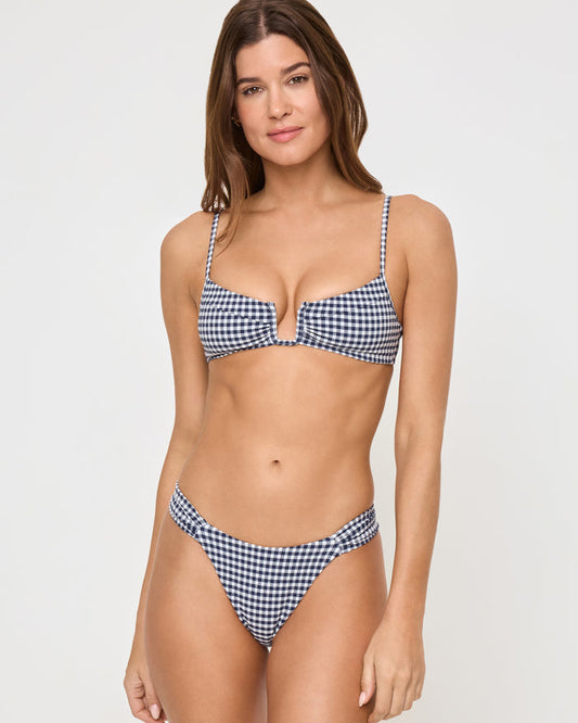 Front view of a model wearing the LSPACE atta girl gingham Peyton Bikini Top in navy and white gingham check with spaghetti straps and center front cutout, paired with matching gingham Dolce Bikini Bottoms.
