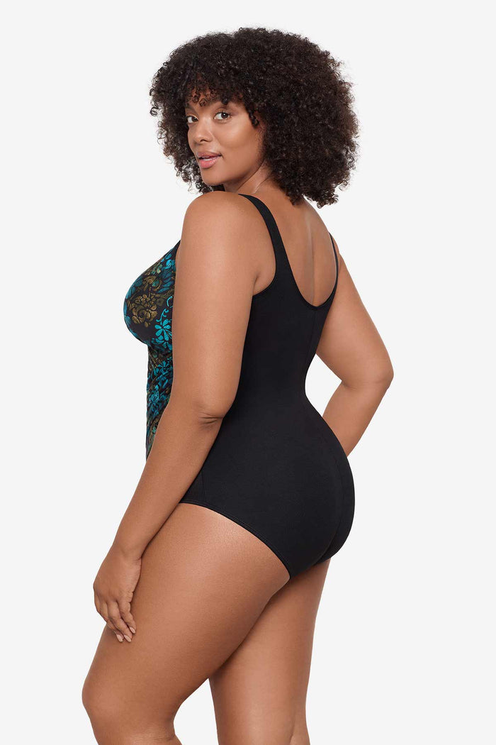 Woman turned to the side to show detail of the one-piece swimsuit