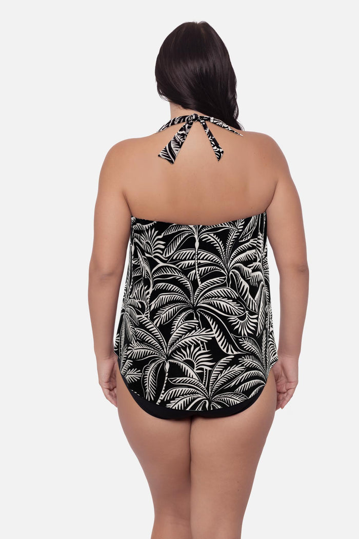 Woman wearing a palm leaf printed tankini top with a halter tie