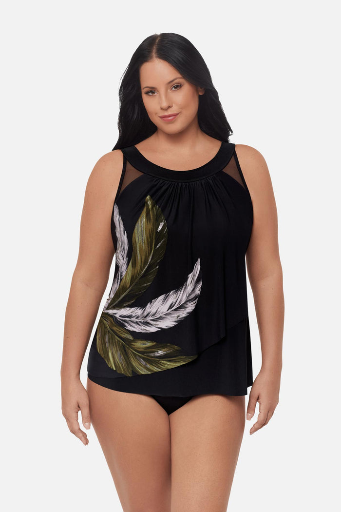 Woman wearing a green and white feather print tankini top