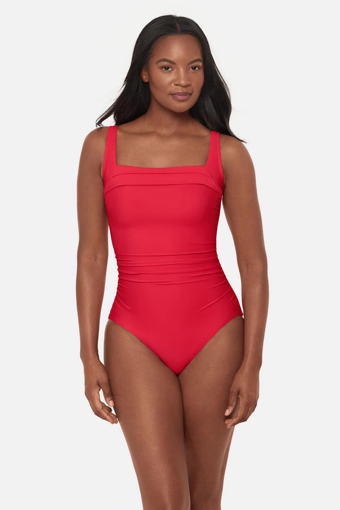Woman wearing an orange/red square neck one-piece swimsuit