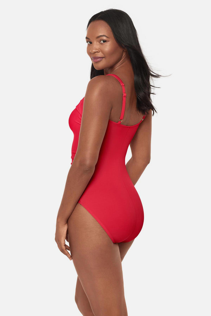 Woman turned left wearing an orange/red square neck one-piece swimsuit