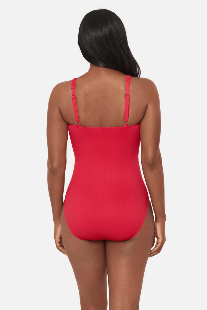 Woman faced away wearing an orange/red square neck one-piece swimsuit