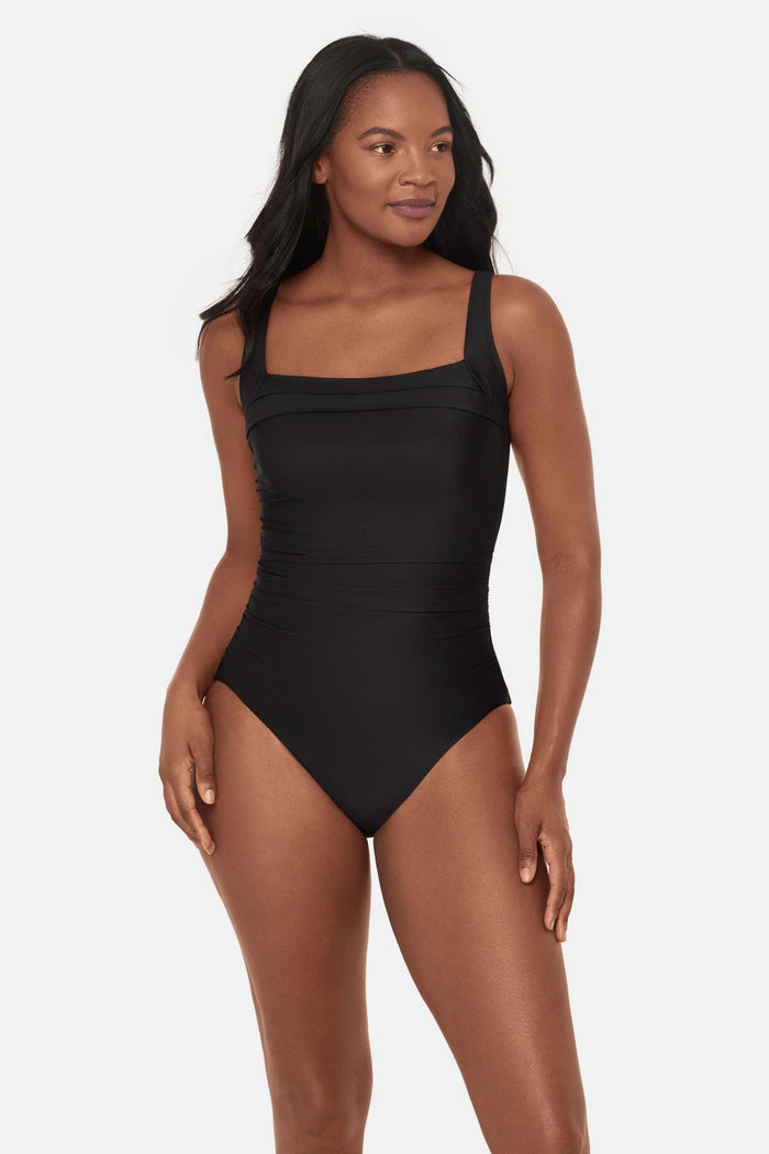 Woman wearing a black square neck one-piece swimsuit