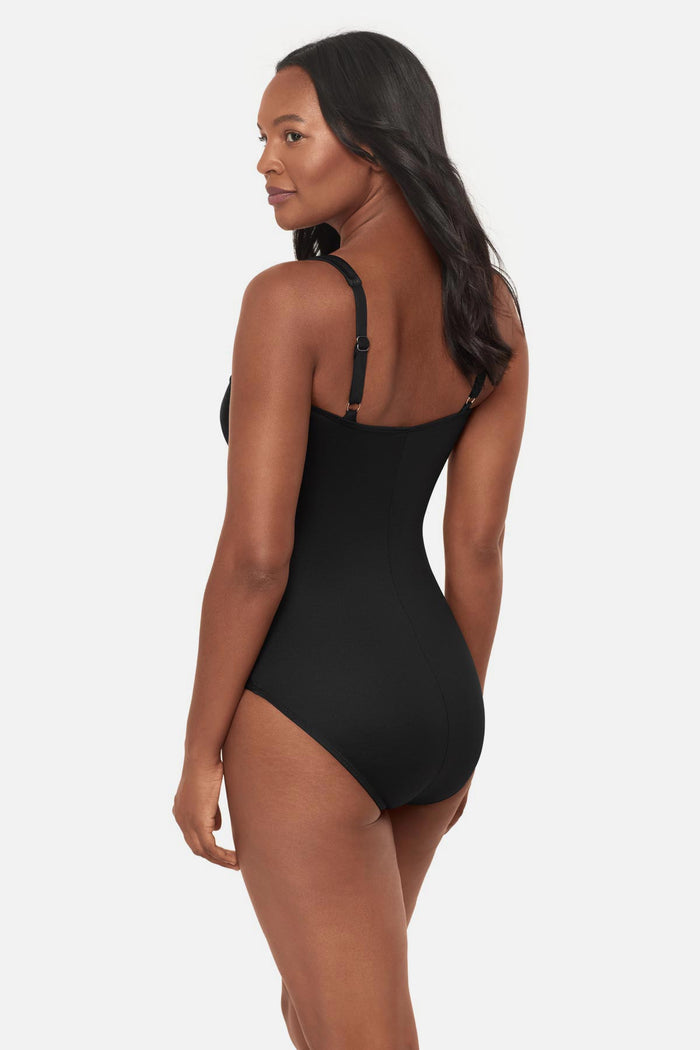Woman turned left wearing a black square neck one-piece swimsuit