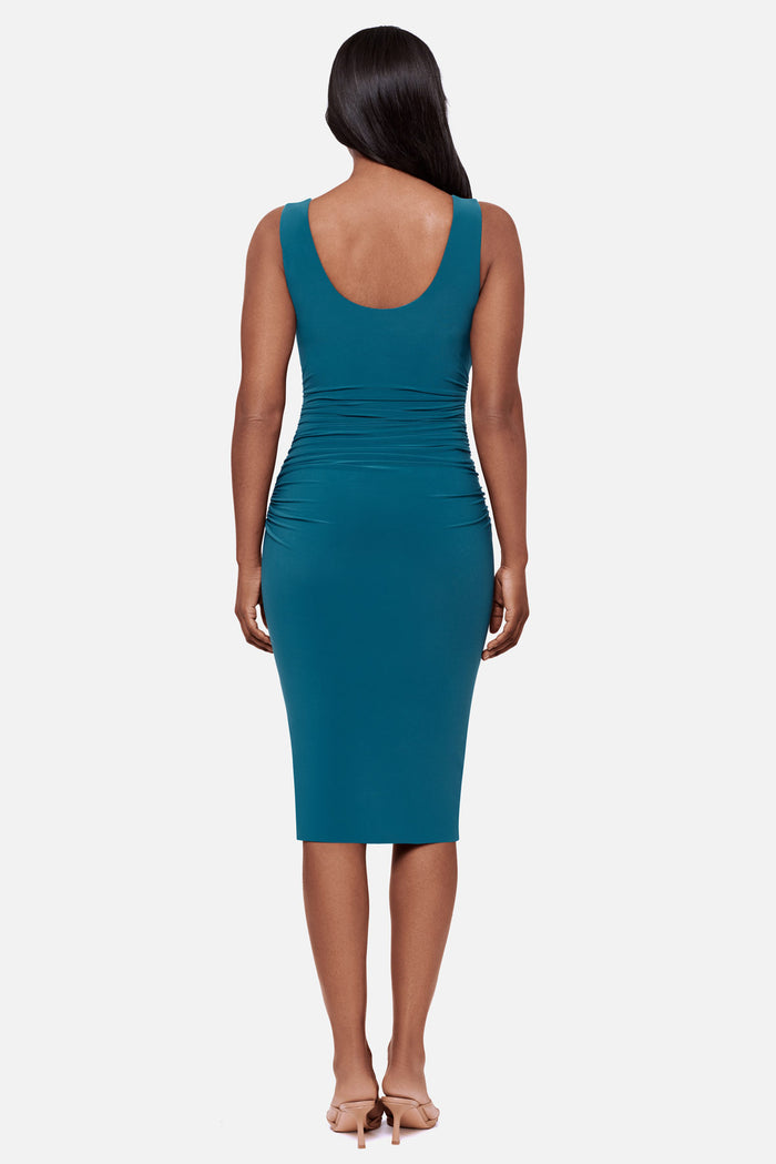 Woman turned away wearing a blue sleeveless mid length dress