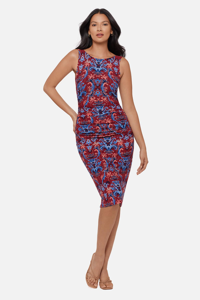 Woman wearing a red and blue paisley-esque sleeveless mid length dress