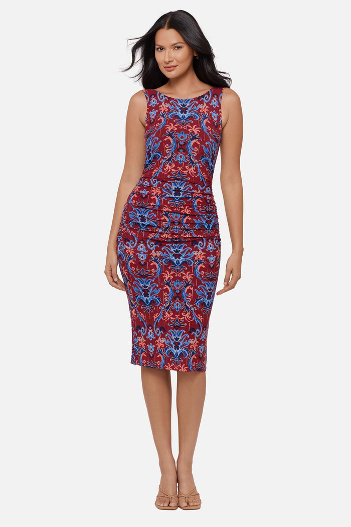 Woman wearing a red and blue paisley-esque sleeveless mid length dress