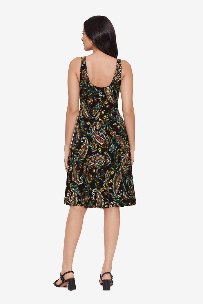Woman turned away wearing a paisley print mid length dress
