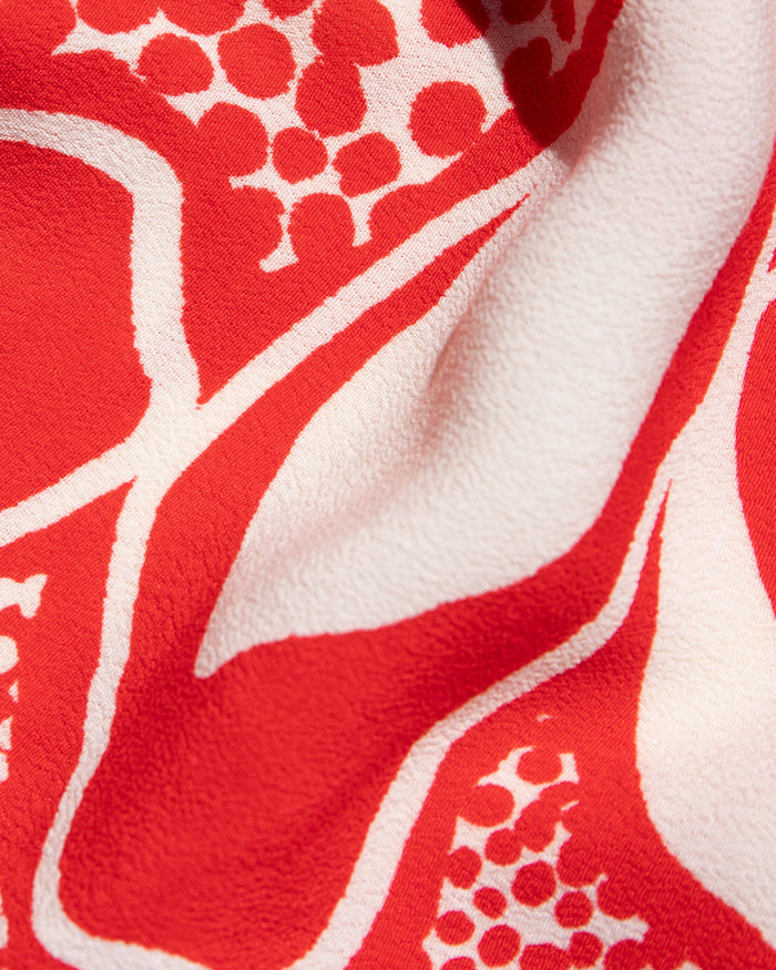 Close-up of the LSPACE Rio Tunic in hibiscus bloom, highlighting the bold red and white hibiscus floral pattern on a textured woven fabric.
