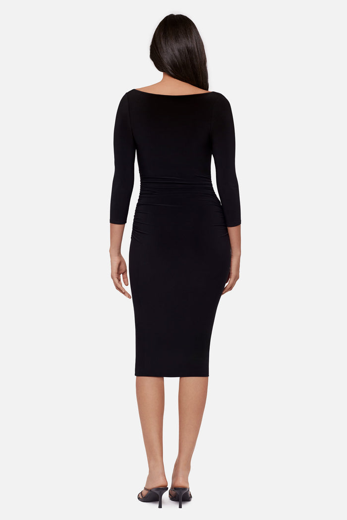 Woman turned away wearing a black 3/4 sleeve mid length dress