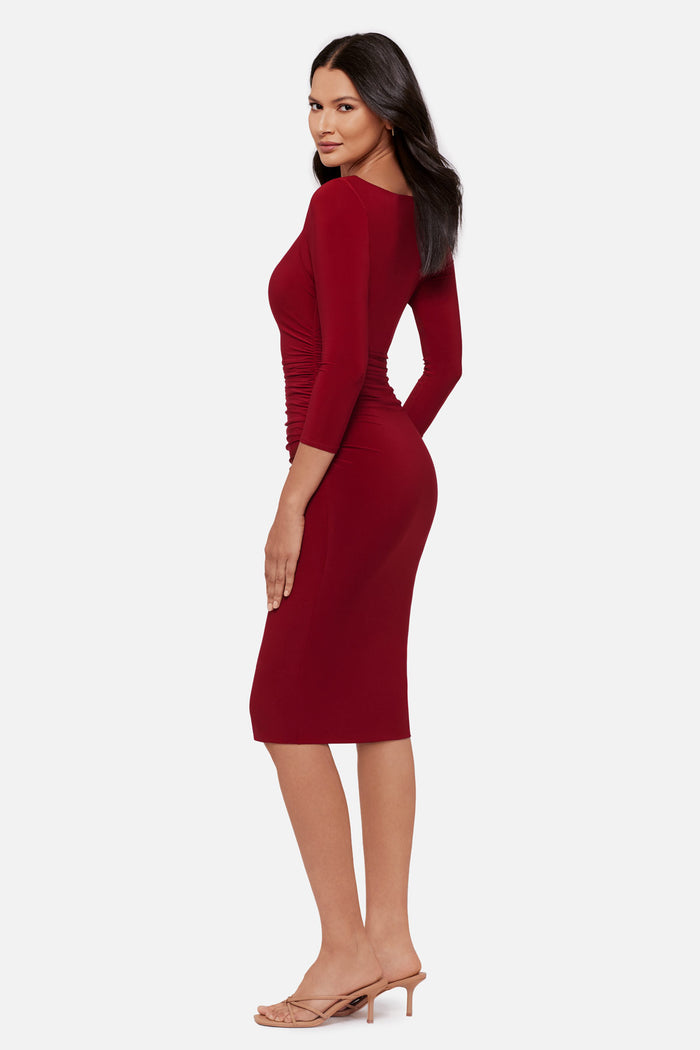 Woman turned left wearing a red 3/4 sleeve mid length dress