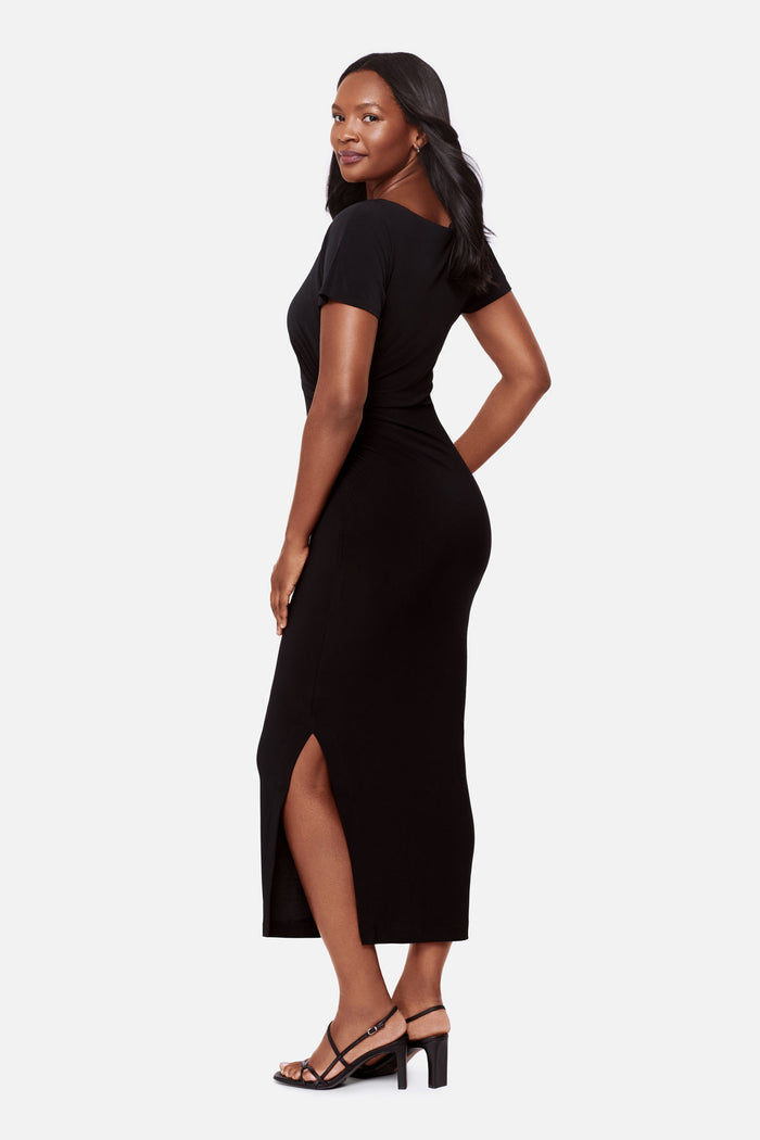 Woman turned left wearing a black short sleeve full length dress