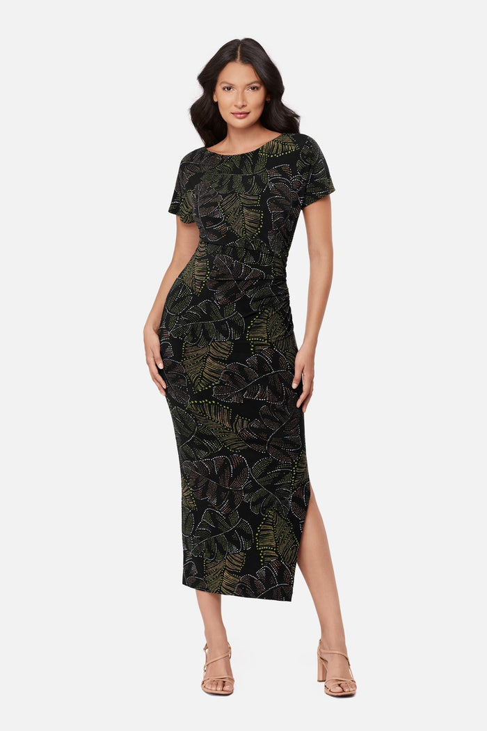 Woman wearing a short sleeve full-length dress with a dotted palm leaf print