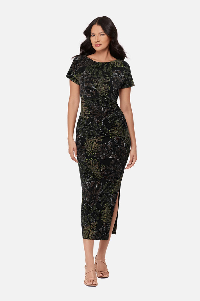 Woman wearing a short sleeve full-length dress with a dotted palm leaf print