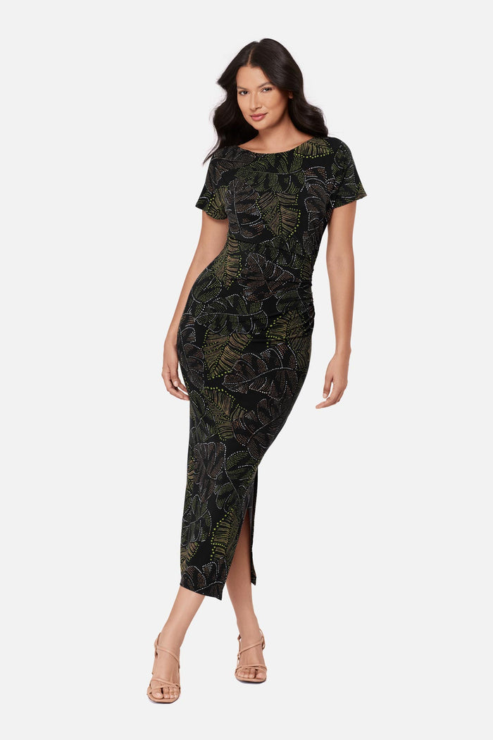Woman wearing a short sleeve full-length dress with a dotted palm leaf print