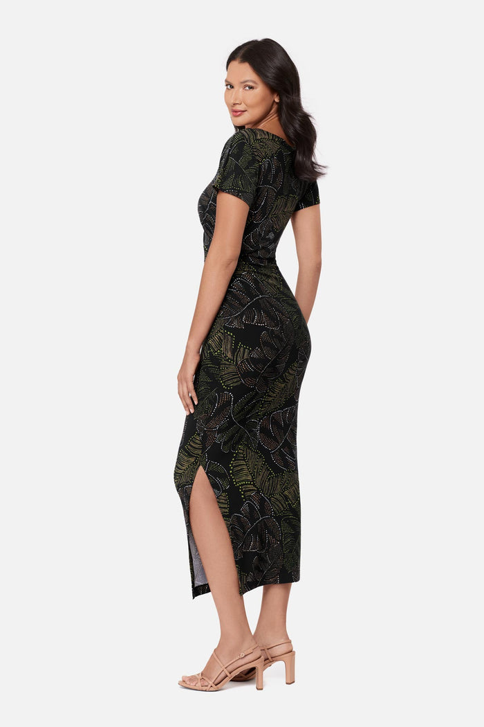 Woman turned left wearing a short sleeve full-length dress with a dotted palm leaf print