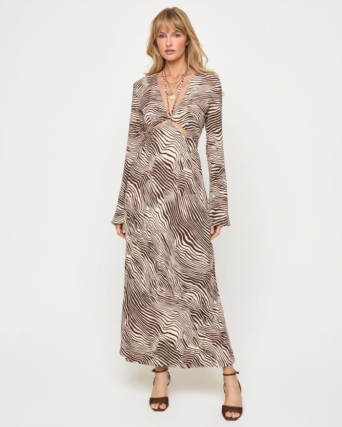 Front view of a model wearing the LSPACE Say When Maxi Dress in animal, a long-sleeve maxi dress with a deep V-neckline, front keyhole cutout, and a warm brown and beige zebra print.