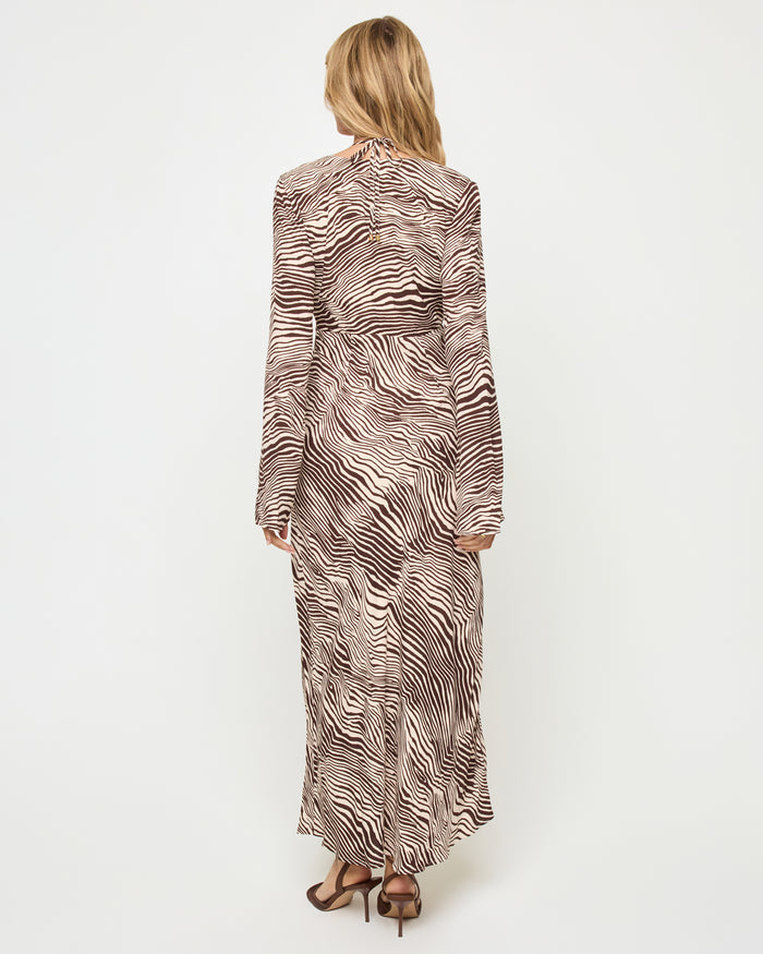 Back view of a model wearing the LSPACE Say When Maxi Dress in animal, showing the long-sleeve maxi silhouette in a warm brown and beige zebra print.