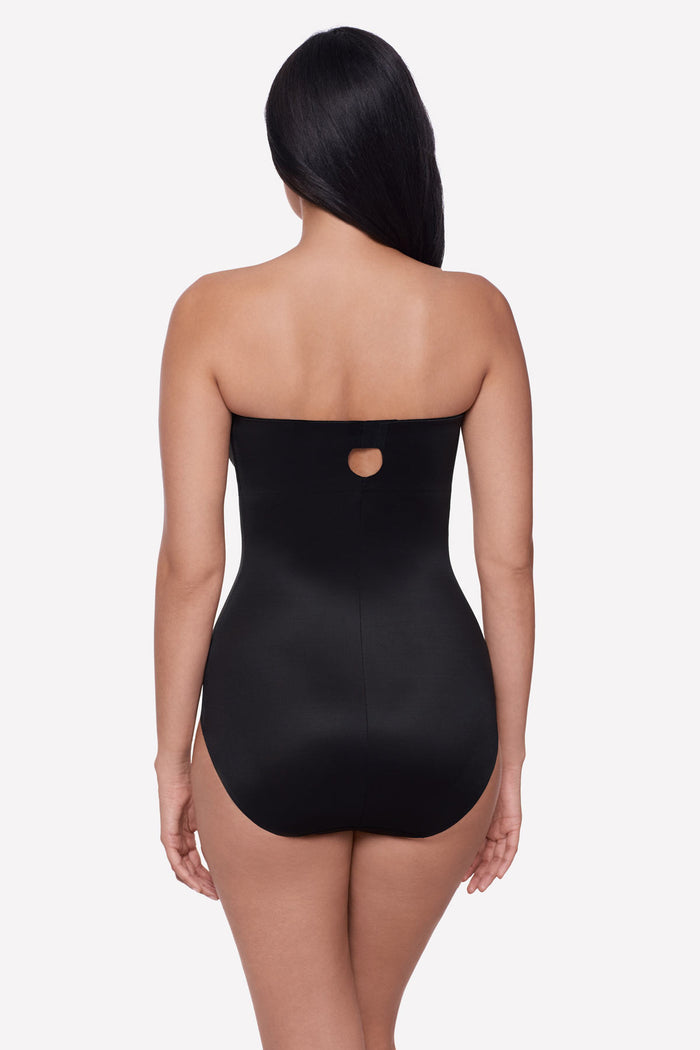 Woman turned away wearing a bandeau style black bodysuit