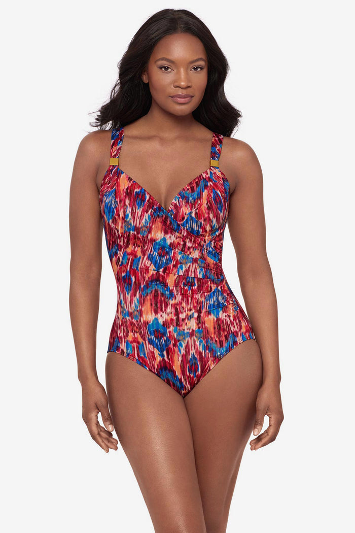 Woman wearing a multicolored one-piece swimsuit with embellishments on the straps