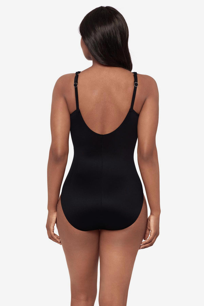 Woman turned away wearing a blue floral printed one-piece swimsuit with a scoop back